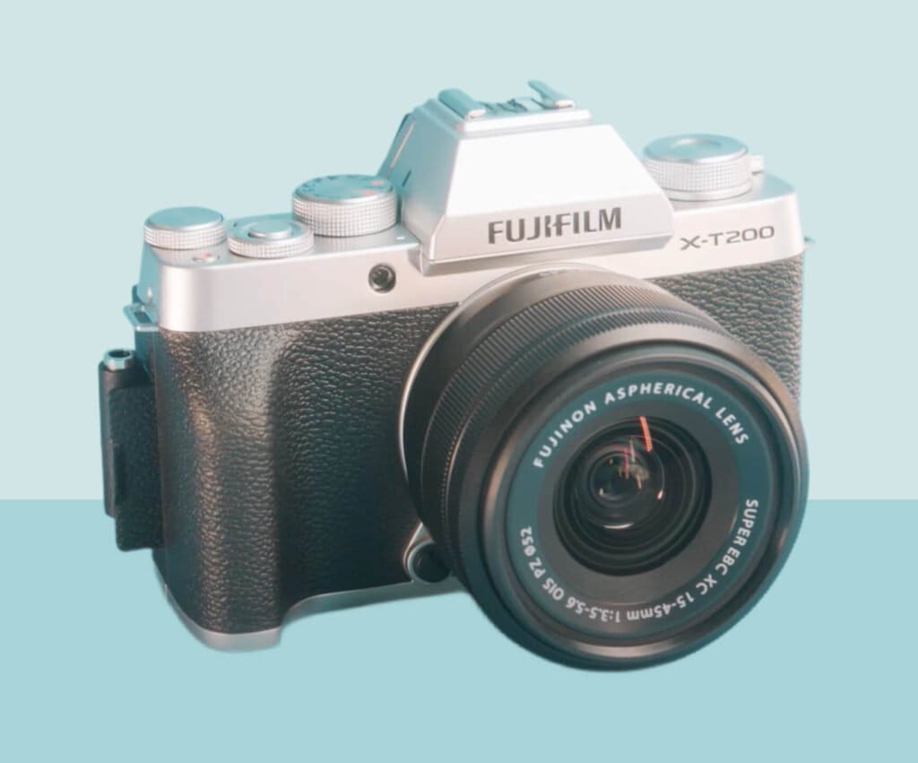 black and grey Fujifilm X-T200 camera with a lens on a blue background